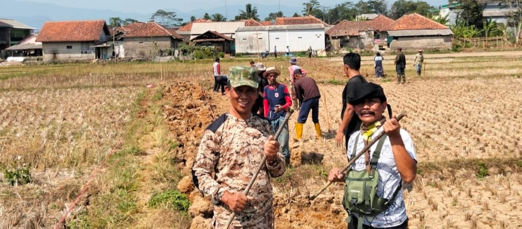 Di Bawah Terik Matahari, Pak Carna Gotong Royong Bersama Warga Bangun Jalan Gang